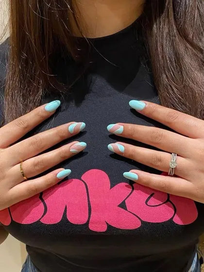 A client showing off her new abstract nails. The light blue and pink design is fun, modern, and totally unique.