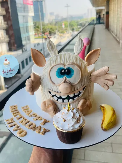I love creating cakes based on beloved characters, like this one of Booba for Miyo's birthday. The entire cake is an edible sculpture, showcasing detailed fondant work, and is paired with a matching cupcake to complete the celebration.