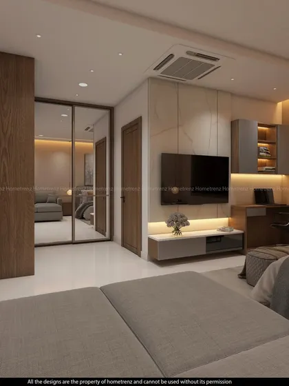 A guest bedroom that combines a TV unit with a study desk. The mirrored wardrobe reflects the space, making it feel open and bright.