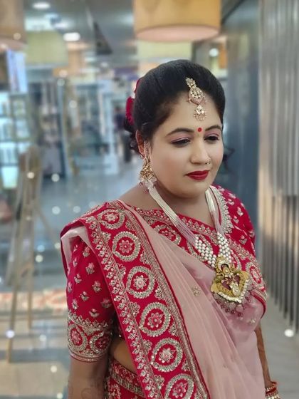 Another angle of this traditional party makeup, showing the neat updo and how the makeup complements her beautiful red and pink saree.
