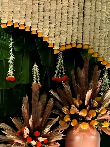 An exquisite fusion of tradition and creativity, this detail shot showcases hanging floral tassels against a backdrop of fresh banana leaves.