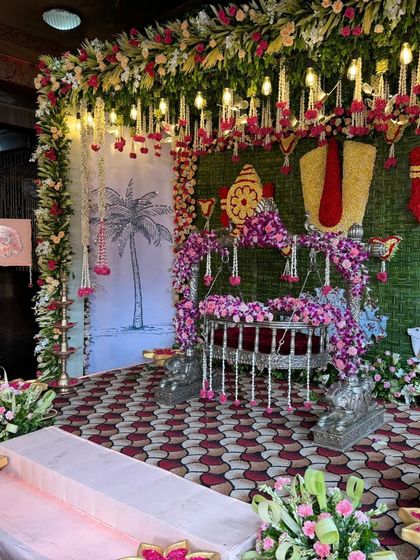An angled view of the cradle ceremony setup, highlighting the hanging floral decorations.