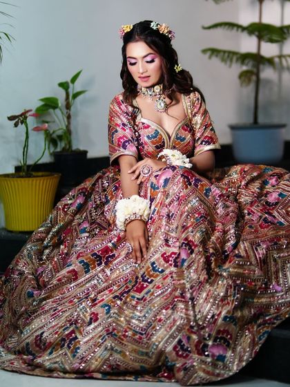 The full view of this colourful and elegant Mehndi look. The makeup is vibrant yet soft, perfectly matching the multi-coloured lehenga.