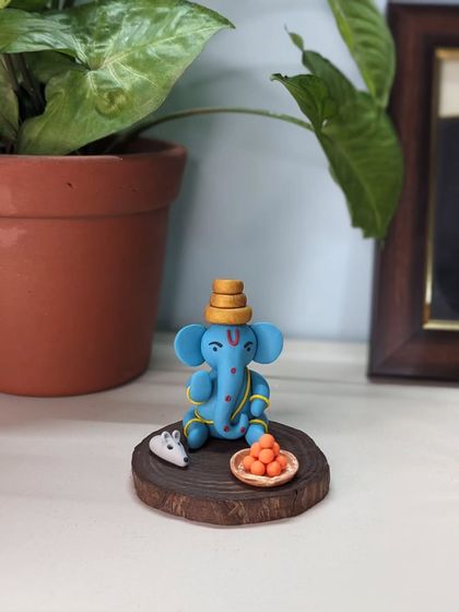 Another view of the blue Ganesha, showing how perfectly it fits into a small, peaceful nook in your home, nestled among plants.