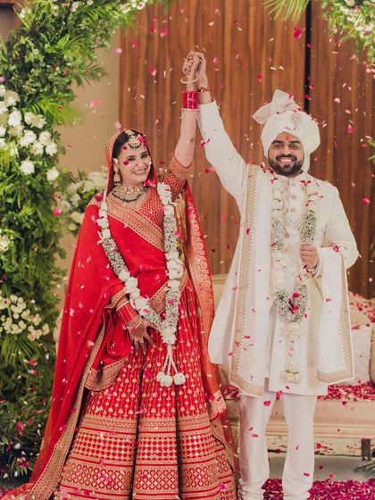 A celebratory shot of the bride and groom. Her classic floral bun is visible even from a distance, adding to the overall grace of her bridal look.