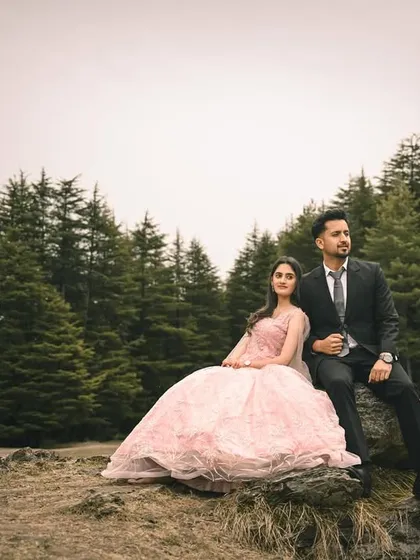 A fairytale scene in a pine forest, with the couple framed by the towering trees. The elegant gown and formal suit create a beautiful contrast with the rustic, natural setting.