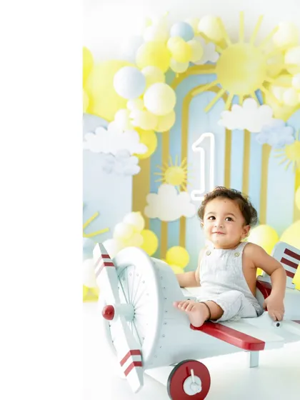 Time to fly! Before the cake, we capture some beautiful portraits with themed props like this charming toy airplane, adding another layer of fun to the first birthday photoshoot.