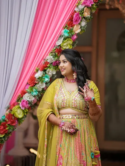 A beautiful portrait of the Haldi bride against a colorful backdrop. Her glowing makeup and happy smile are infectious.