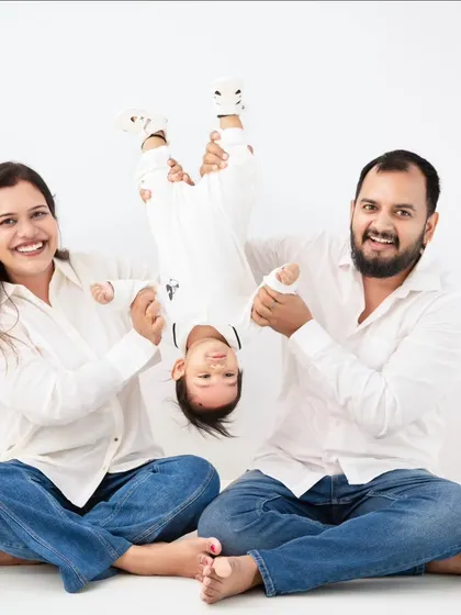 Pure, unscripted joy. We believe in capturing the chaos and laughter just as much as the calm. This playful moment, with the family dressed in coordinated white and denim, shows the fun we have in our studio.