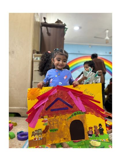 A beaming smile and a colorful craft. This is what joyful, hands-on learning looks like.