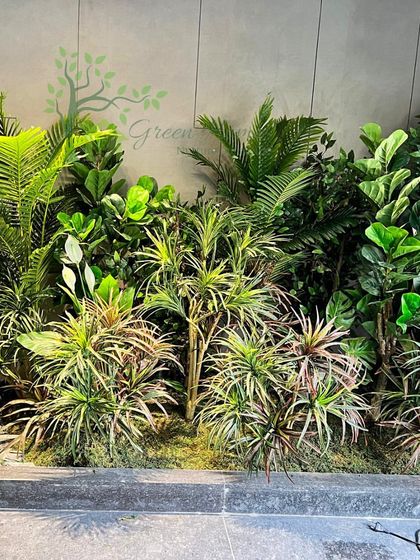 The garden is beginning to take shape. Here you can see the dense layering of different types of artificial foliage, creating a rich and textured look before the final lighting and finishing touches are added.