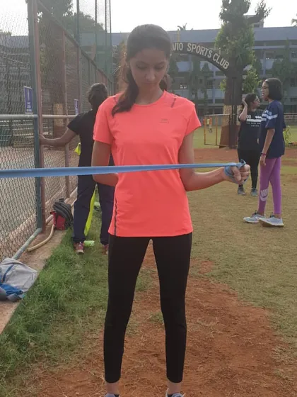 This image shows the external rotation phase of a theraband exercise. This movement specifically targets the rotator cuff muscles, helping to prevent common shoulder injuries in athletes.
