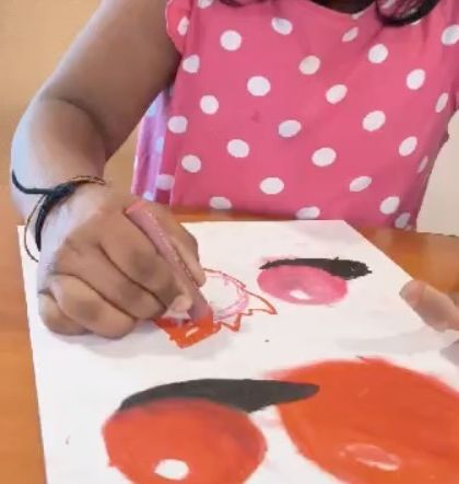 A student works on the details of her fruit painting, learning about light, shadow, and form with colorful pastels.
