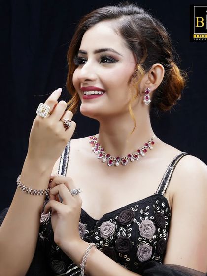 This image from a jewelry shoot features a different set of ruby accessories. The hairstyle remains a consistent, elegant updo, providing a cohesive look for the brand's campaign while allowing each jewelry piece to stand out.