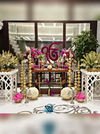 A full view of the 'Ek Onkar' setup, showing the intricate floral work and the balance of modern and traditional elements. We take pride in creating decor that is both beautiful and meaningful.