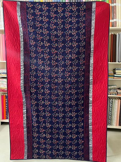 The front view of the red and blue saree quilt, with the fabric's original border creating a beautiful frame.