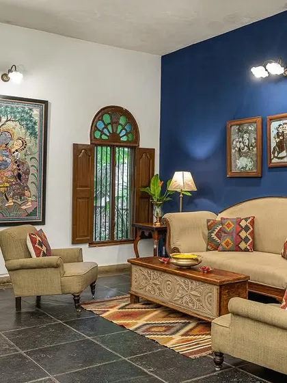The Vasishta suite's living area, with its deep blue wall and curated artwork, provides a sophisticated and calming space.