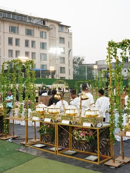 An outdoor event calls for a fresh and elegant setup. Here, I used golden stands and green vine accents to create a beautiful garden party feel, with our professional staff ready to serve.