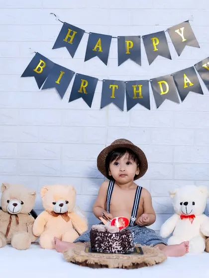 A classic first birthday setup before the smashing begins, featuring a 'Happy Birthday' banner, 'ONE' blocks, and teddy bears.