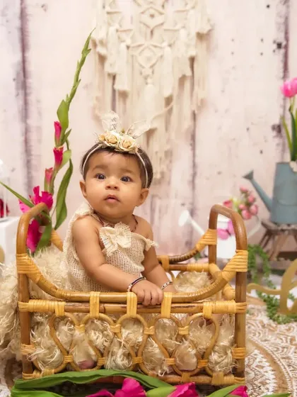 A classic half-birthday portrait with a rustic, bohemian floral theme. The '1/2' sign and natural props create a timeless look.
