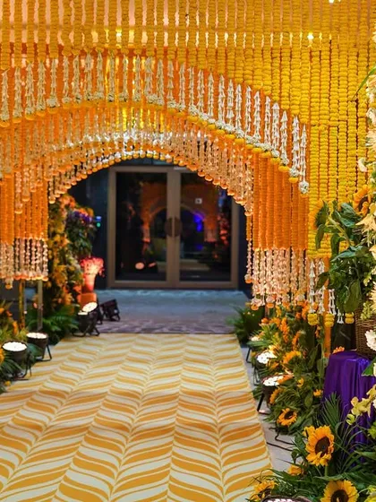 A grand entrance tunnel created entirely from strings of marigolds and tuberoses. This immersive floral experience makes for a spectacular welcome for guests.