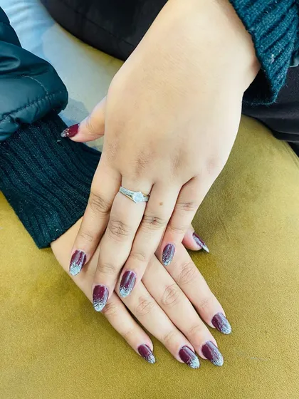 This manicure combines rich color with sparkling glitter. I created a deep maroon base and added a silver glitter ombre effect on the tips for a dramatic and festive design.