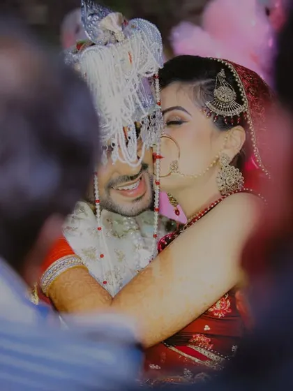 Creating memories as timeless as your love. A candid, intimate hug between the bride and groom, captured through a crowd of loved ones.
