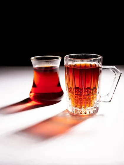 A composition with two different Turkish tea glasses, showing the interplay of their shapes and shadows.