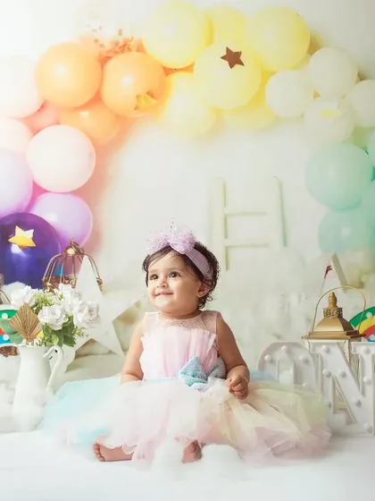 A magical rainbow and stars theme for a very special first birthday girl. Her happy expression lights up the whole scene.