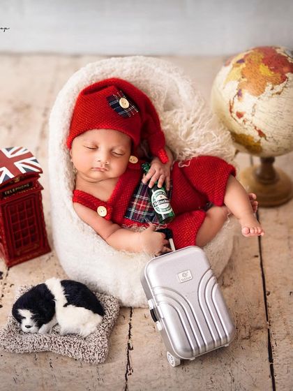 Ready for an adventure. This 'Little Traveler' theme features a globe, a mini suitcase, and a London telephone booth prop for a creative and worldly newborn portrait.