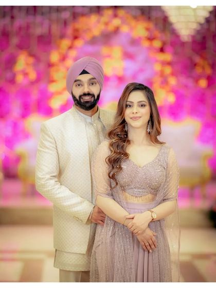 A beautiful portrait from Simran and Sanjit's Roka ceremony. Their coordinated pastel outfits and the vibrant pink floral decor create a soft and romantic atmosphere.