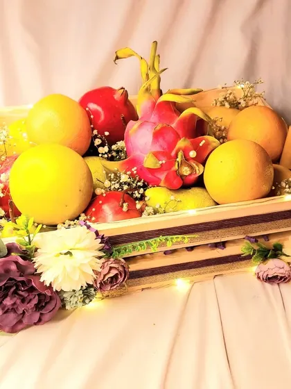 A fresh fruit basket is a wonderful and healthy addition to any wedding trousseau. I arrange a colorful selection of seasonal fruits in a decorated wooden crate, adding flowers and lights for a festive touch.