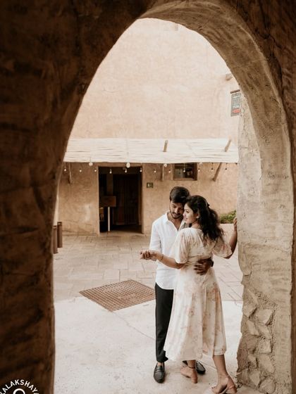 A romantic dance framed by an archway in Old Dubai, capturing a moment of quiet intimacy.