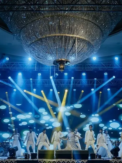 A spectacular performance on the Sangeet stage, with the giant ballroom chandelier and dynamic lighting creating a truly cinematic moment.