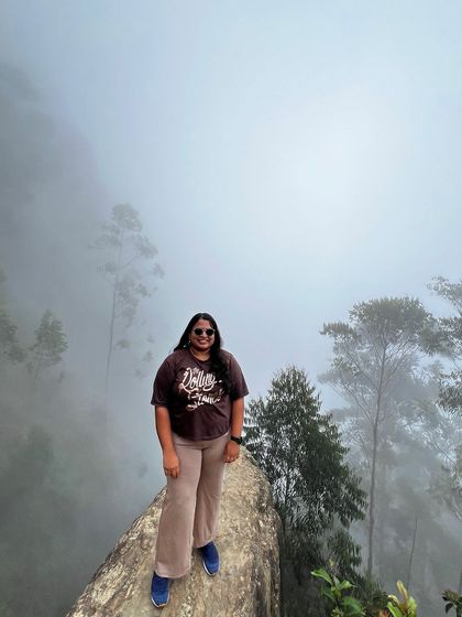 A trekker on the edge of Dolphin's Nose, surrounded by fog.