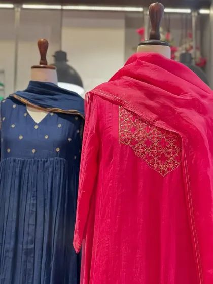 A beautiful trio of anarkalis in navy blue and fuchsia pink. The pleated skirts and delicate embroidery offer a look of timeless grace.
