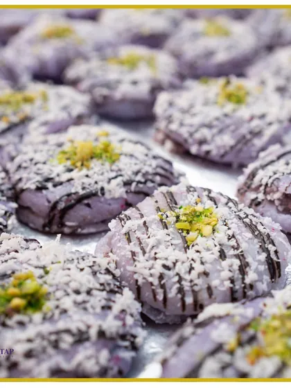 Indulge in our handcrafted Jamun Macaroons. This fusion dessert combines the classic Indian sweet with a French patisserie technique, topped with coconut and pistachio.
