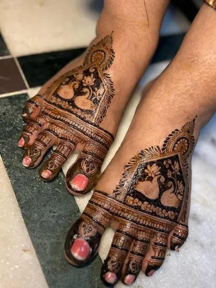 Your feet deserve beautiful art too. This bridal foot mehendi features a pair of graceful swans, a symbol of love and partnership, surrounded by intricate patterns covering the toes and top of the foot.