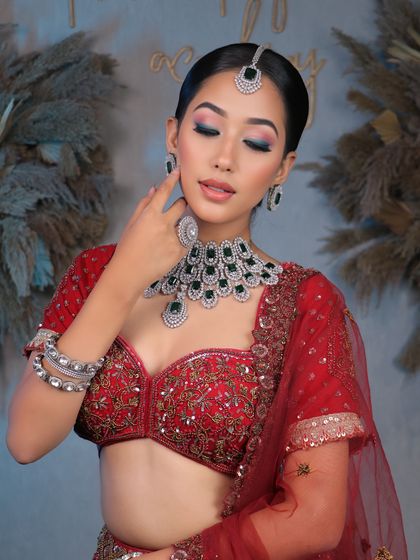 Unveiling bridal elegance that takes your breath away. This look features a clean, sophisticated bun and soft, glowing makeup that complements the diamond and emerald jewelry.