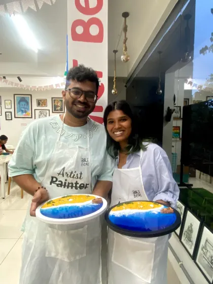 A couple showing their finished resin beach art. It's a great way to create something beautiful together and have a unique piece of decor for your home.