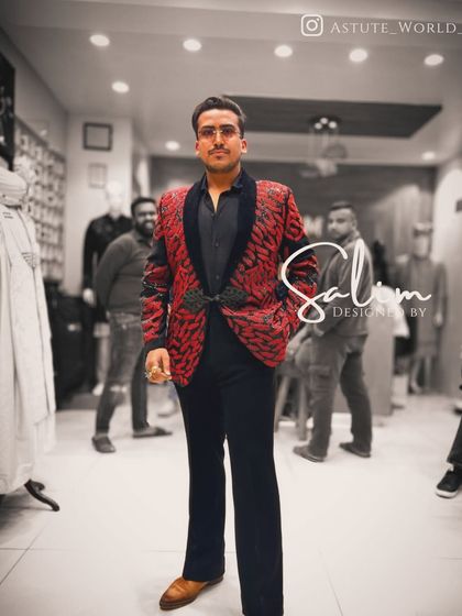 A client in a bold red and black patterned tuxedo jacket. This piece is for someone who isn't afraid of color and wants to make a strong style statement.