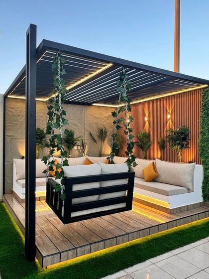 A cozy corner pergola with built-in seating and a hanging swing. We use elements like climbing ivy and integrated lighting to make these structures feel like a natural part of the garden.