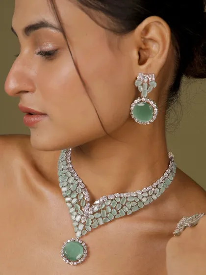 For a touch of modern elegance, this mint green American diamond necklace set offers a fresh and sophisticated look. The clean lines and sparkling stones make it a versatile choice for cocktail parties, receptions, or any contemporary celebration.