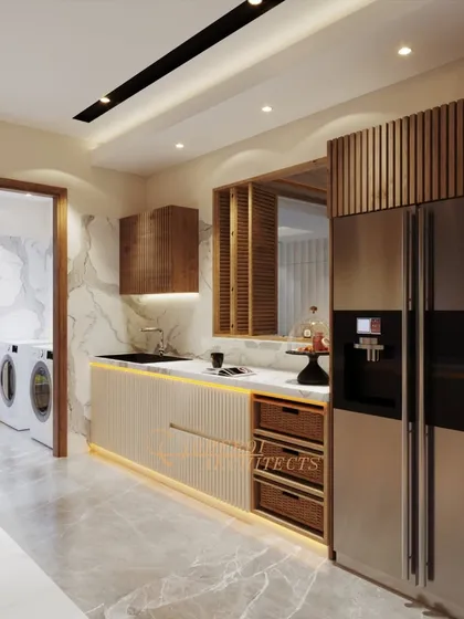 A galley kitchen design that maximizes efficiency in a compact space. It features fluted wood cabinets, a stainless steel refrigerator, and a small laundry area at the end.