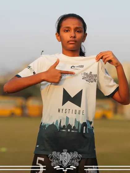 Pointing to the crest. A player proudly shows off the team logo, representing our shared goals.