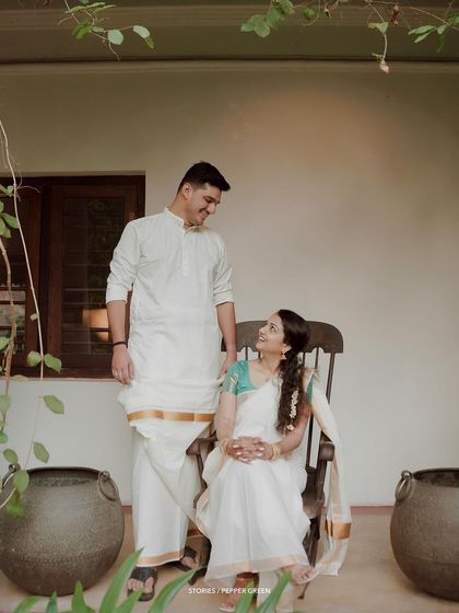 A relaxed and happy portrait of the couple on a veranda, the groom looking lovingly at his seated bride.