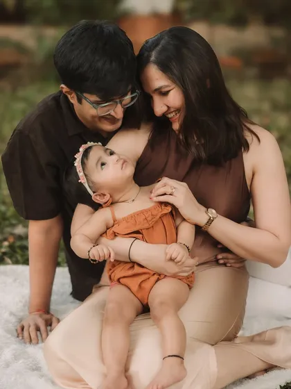 A tender moment where the parents are lovingly looking at their baby girl.
