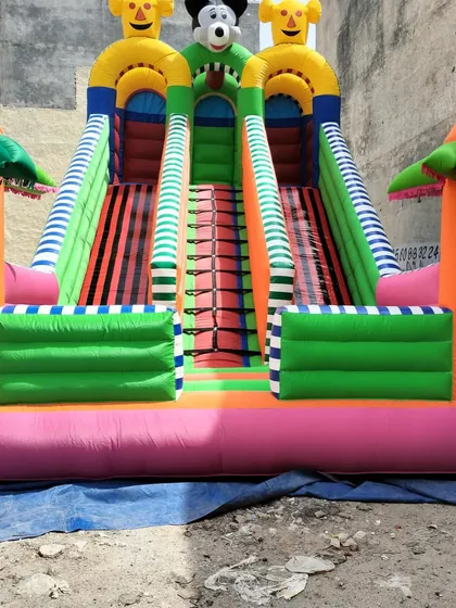 A 3-slider bouncy in a green and pink color scheme with striped slide lanes.