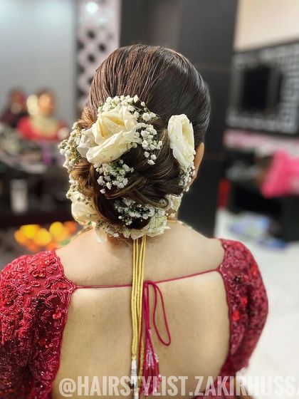 A close-up of the traditional bridal bun with white roses, showing the full and lush floral arrangement.