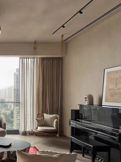 A playful swing and a classic piano add character to this living area. The design combines unique personal touches with a refined aesthetic, creating a space that is both elegant and lived-in, all against the backdrop of a stunning city view.
